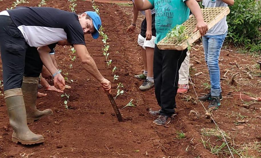 Alunos ajudando no plantio.